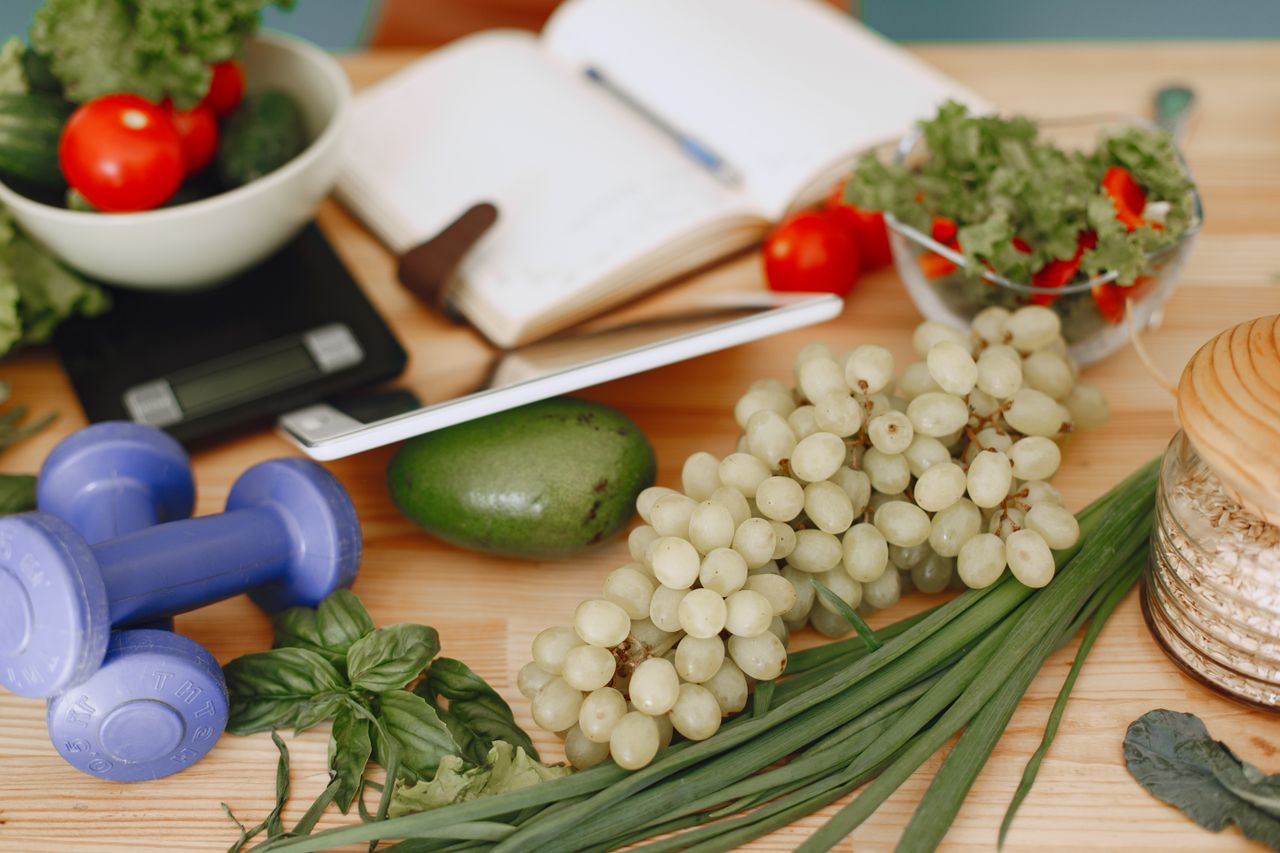 about-us-02 A vibrant composition of fruits, vegetables, and fitness items promoting a healthy lifestyle.
